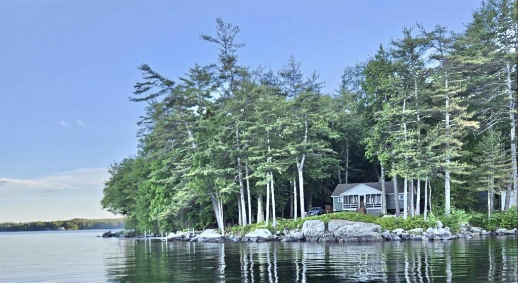 a house on a small island in the water at PLACYD PINES LIMIT 8 cottage in North Sebago
