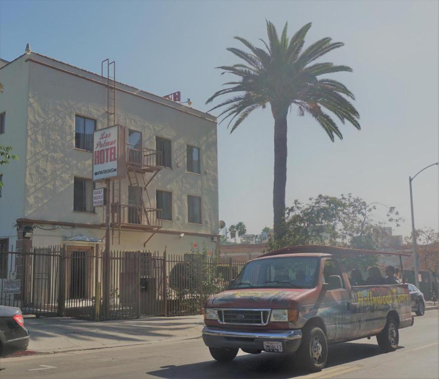 a truck driving down a street with a palm tree at Las Palmas Hotel in Los Angeles