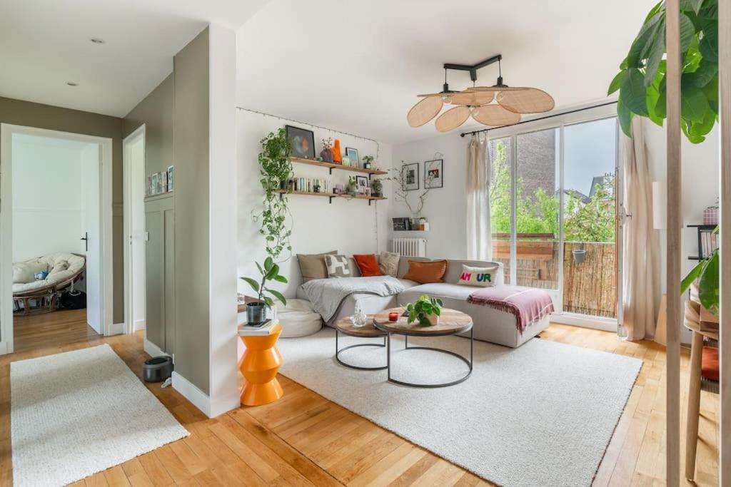un salon avec un canapé et une table dans l'établissement Appartement cosy Bois colombes, à Bois-Colombes