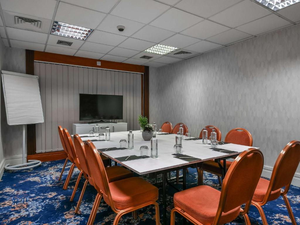 a conference room with a long table and chairs at Pullman Bucharest World Trade Center in Bucharest