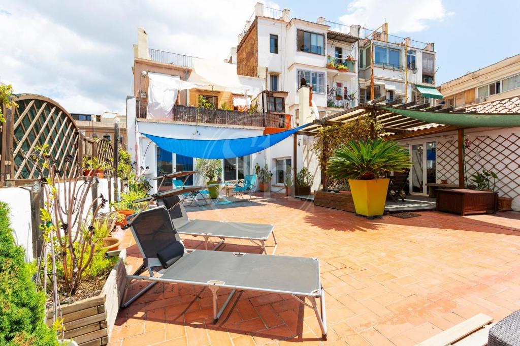 un patio avec deux chaises et un hamac dans l'établissement Apartamento con Terraza en Poble Sec, à Barcelone