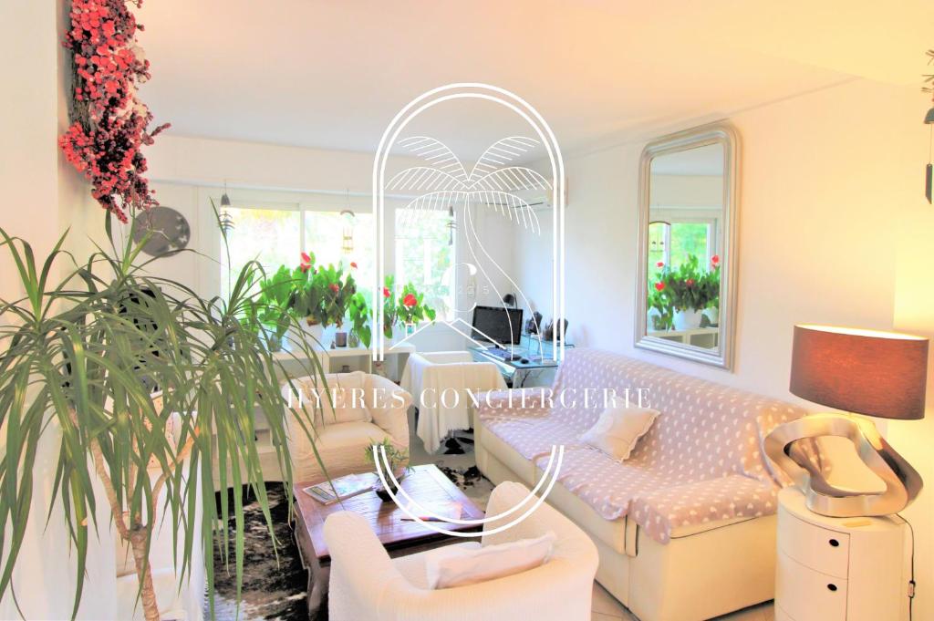 un salon avec un canapé et une table dans l'établissement Cosy T3 rénové Clim Parking Hyères Plage 10 min By HC, à Hyères