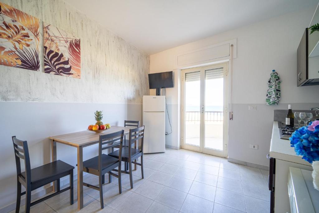a kitchen with a table and chairs and a refrigerator at Appartamento Fronte Mare in Marina di Strongoli