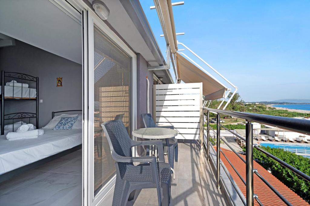 a balcony with a bed and a table and chairs at Iguana studio 18 in Preveza