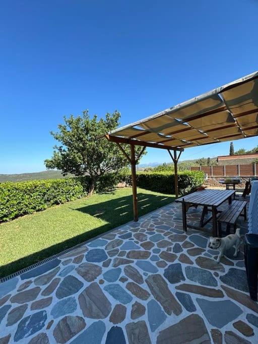 a patio with a picnic table and a bench at Villa Bournous in Mesokhória