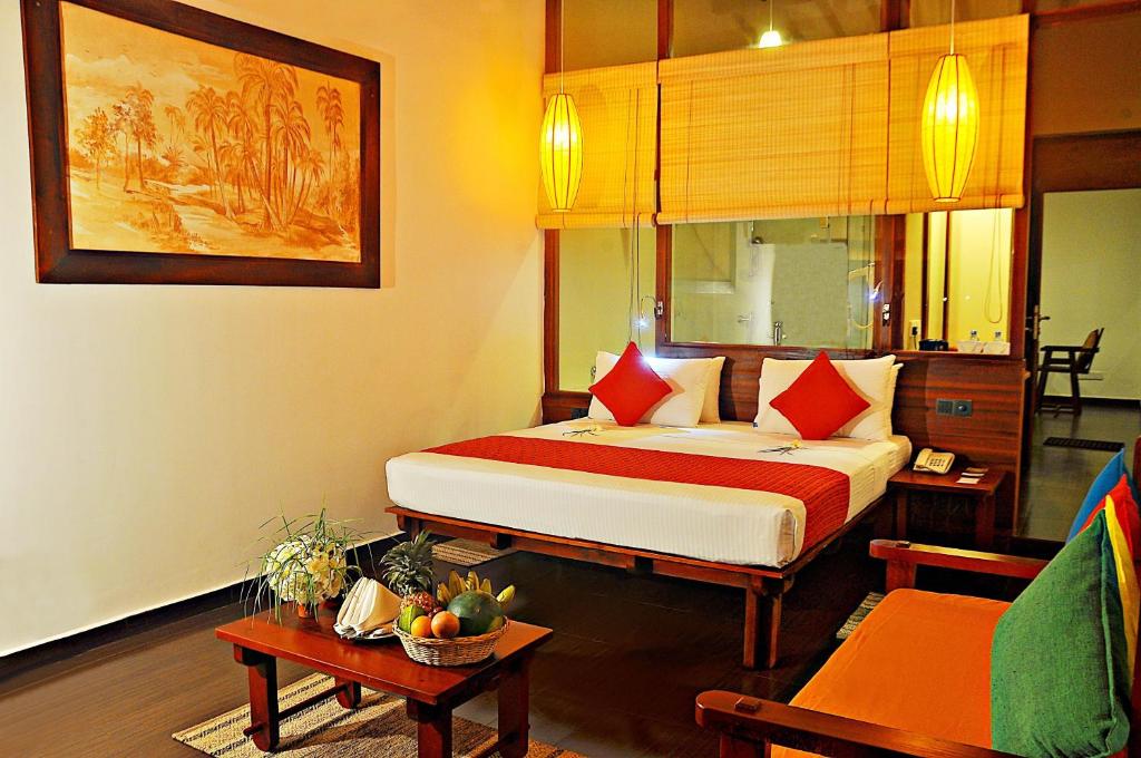 a bedroom with a large bed with red pillows at The Beach Cabanas Retreat & Spa in Koggala