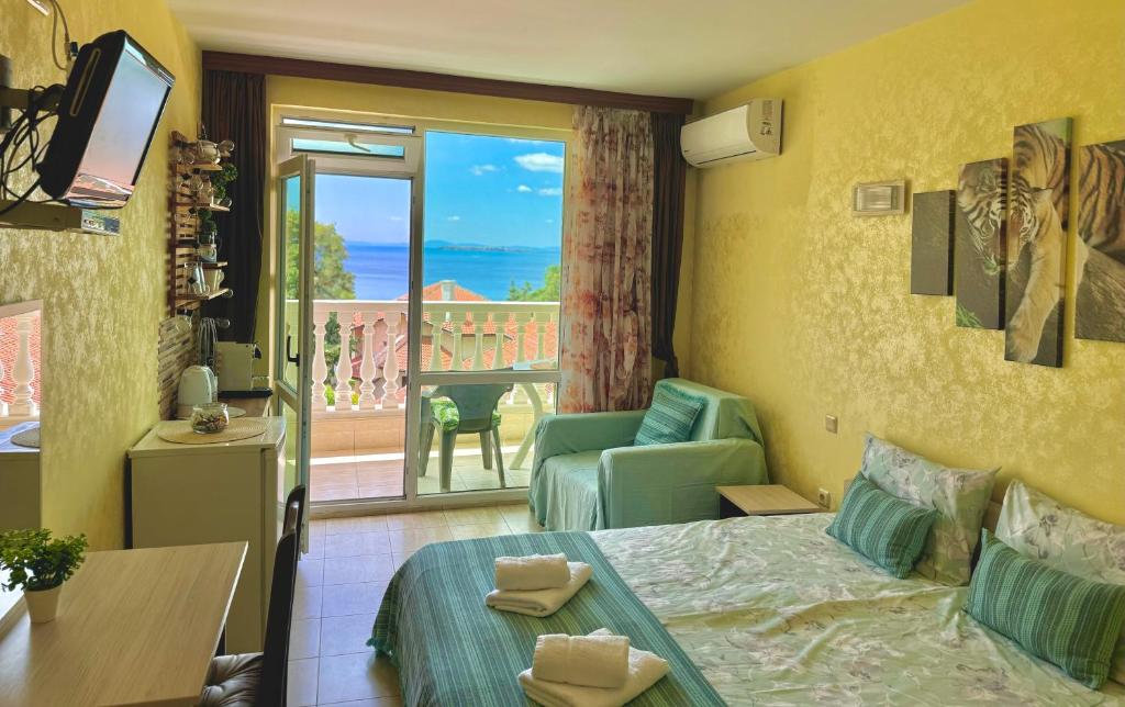 a hotel room with a bed and a balcony at Aqua Studio - Sveti Vlas in Sveti Vlas