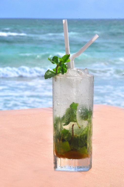 a drink sitting on the beach near the ocean at The Beach Cabanas Retreat & Spa in Koggala