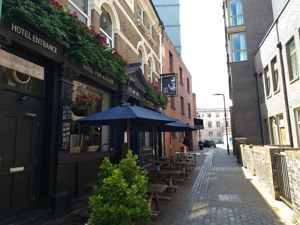 un vicolo con tavoli e ombrelloni su una strada di Old Ship Inn Hackney a Londra