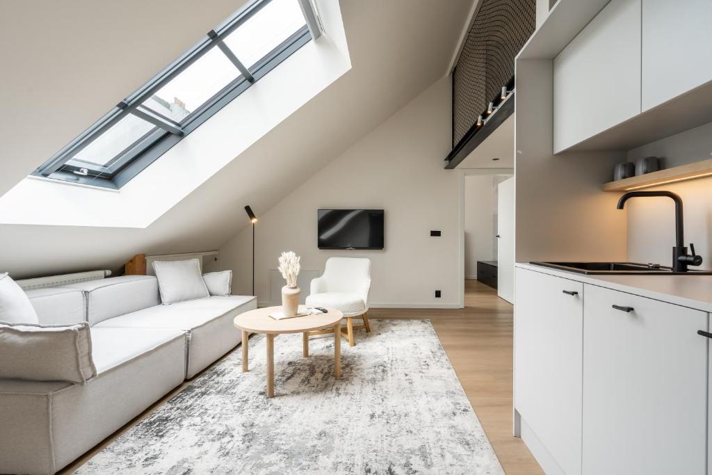 a living room with a white couch and a table at HONEST Karlin in Prague