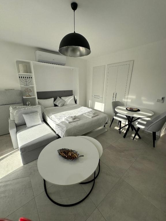 ein Wohnzimmer mit einem Bett und einem Tisch in der Unterkunft Студия в комплексе Thalassa с видом на горы in Elea
