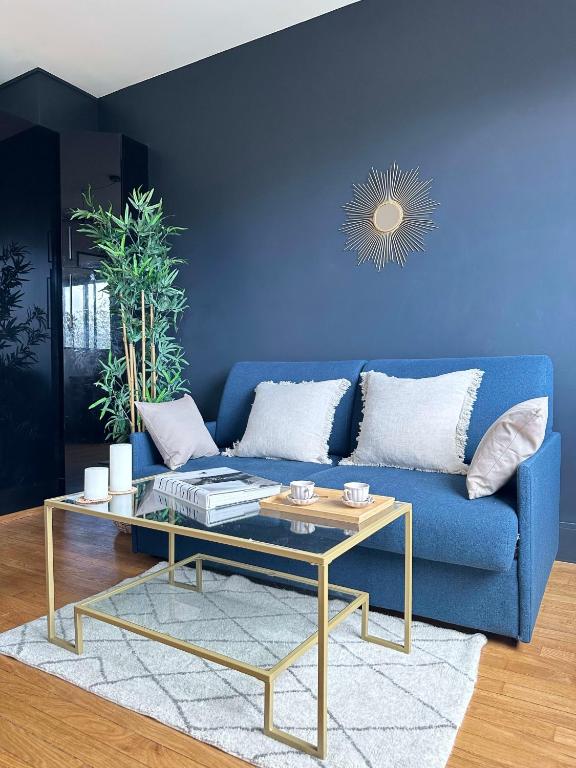 niebieska kanapa ze stolikiem kawowym w salonie w obiekcie Stylish Apartment with a Balcony in Paris w Paryżu