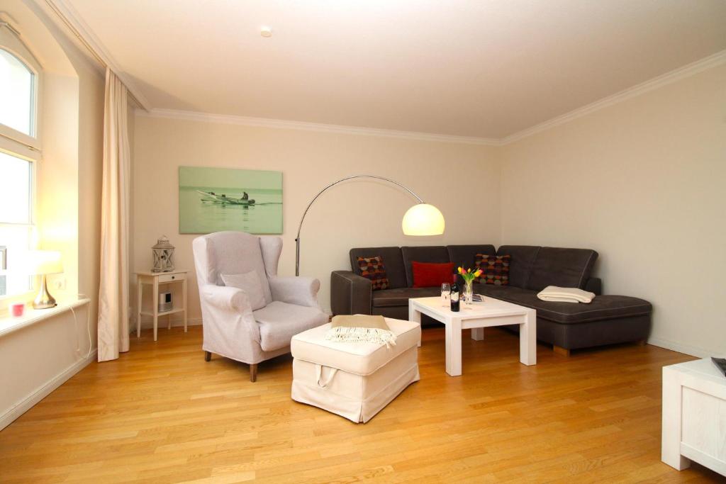 a living room with a couch and a chair at Jagdschloß zu Hohen Niendorf Fewo 13 in Hohen Niendorf