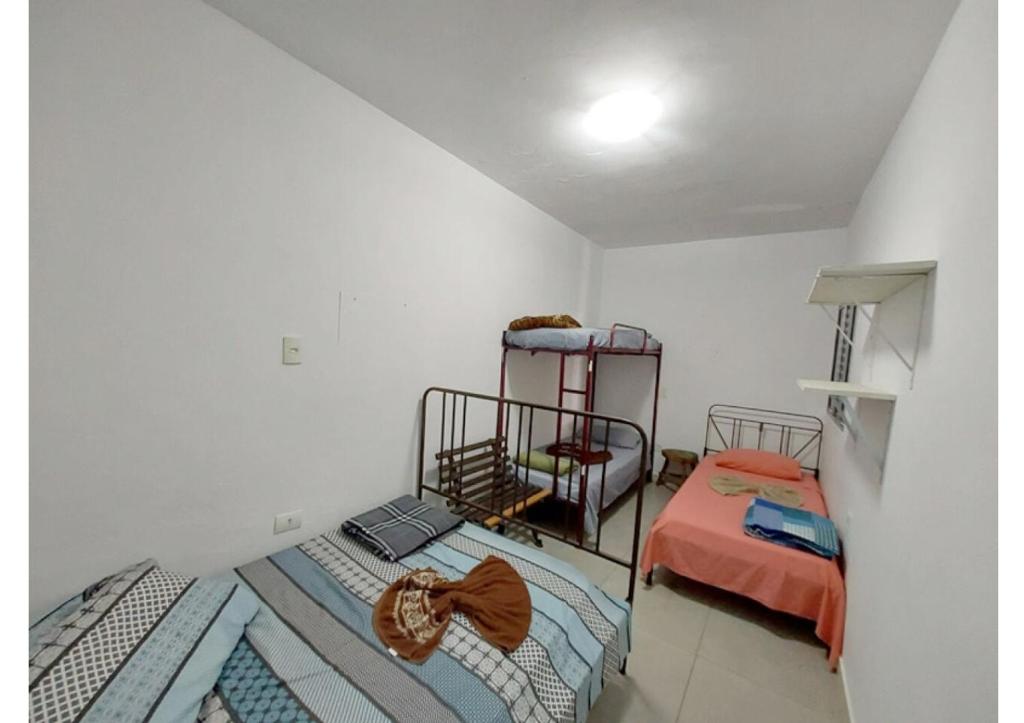 圣保罗Girassol Hostel Vila Madalena的一间白墙房间里有两张单人床