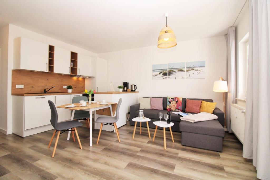 a living room and kitchen with a table and a couch at Ostseeresidenz Appartements Wischuer Fewo 23 in Wischuer