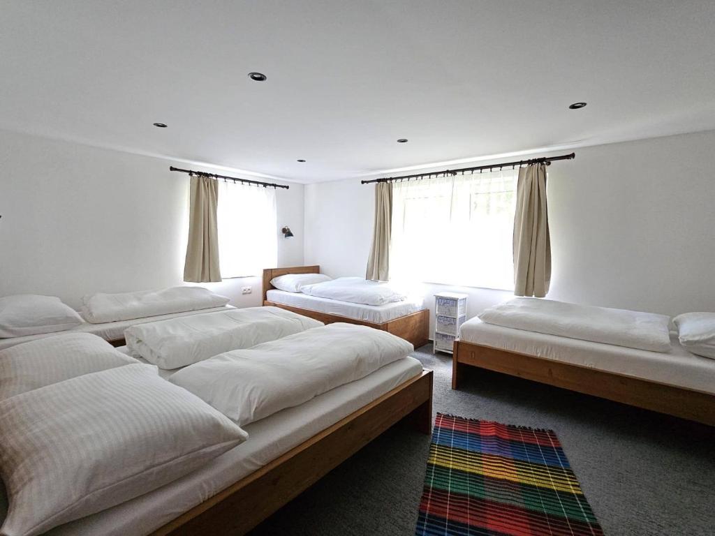 a bedroom with four beds and a window at Chata Partizánka in Liptovský Ján