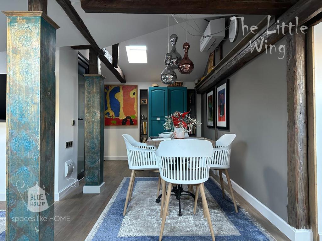 a dining room with a white table and chairs at Пространства за гости Синият час - апартамент Little Wing in Ruse