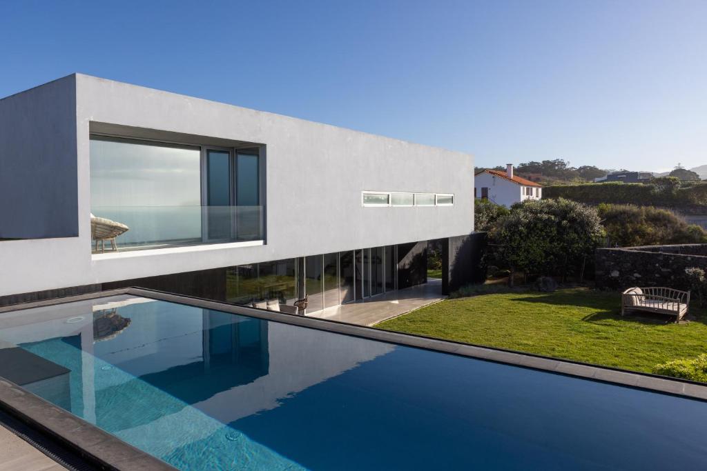 a house with a swimming pool in front of it at White Exclusive Suites & Villas in Lagoa