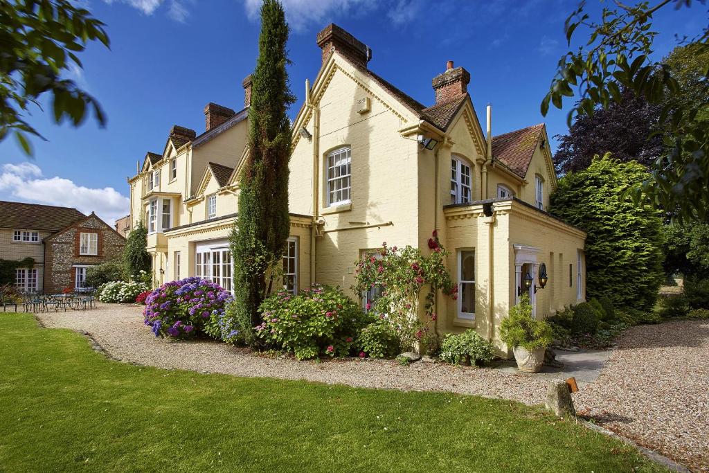 una casa grande con flores en el patio delantero en Esseborne Manor, en Hurstbourne Tarrant