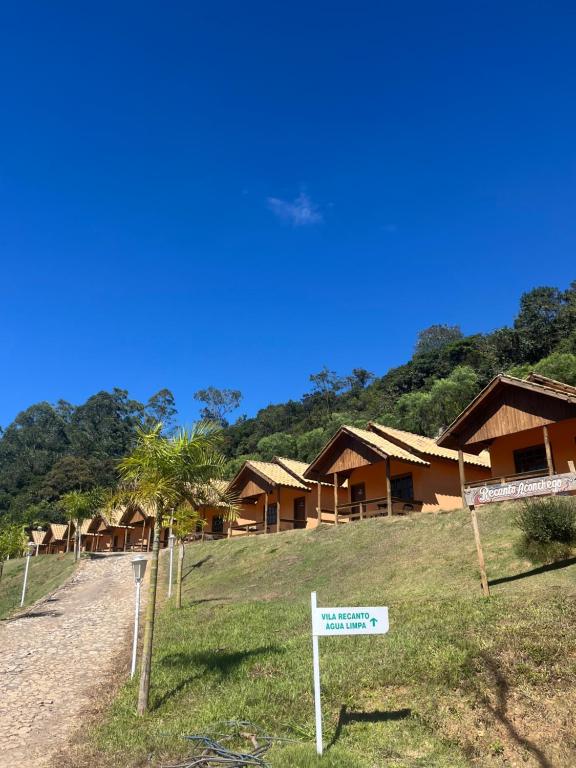 a row of cottages with a sign in front at Hotel Fazenda Recanto in Ouro Branco