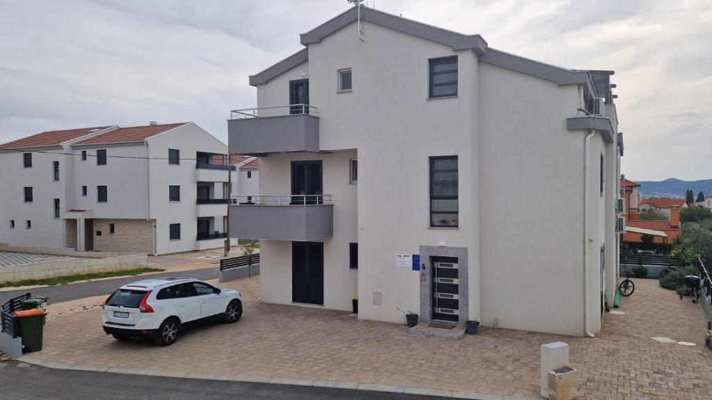 a white house with a car parked in front of it at Villa Toni II in Biograd na Moru