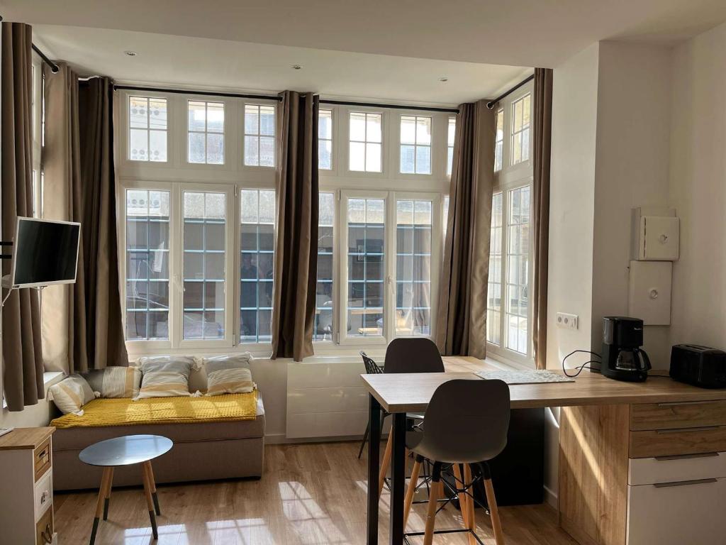 Cette chambre comprend un lit, un bureau et des fenêtres. dans l'établissement Charmant Studio Rénové à Deux Pas de la Plage et des Commerces - FR-1-674-44, à Berck-sur-Mer