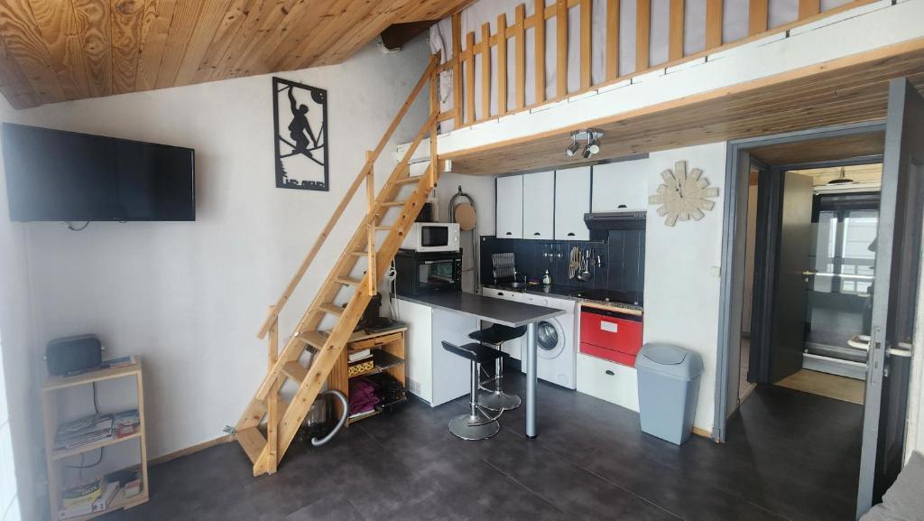 une petite cuisine avec un escalier dans une petite maison dans l'établissement Vista Matémala - Appartement avec Vue Lac et Montagne, aux Angles