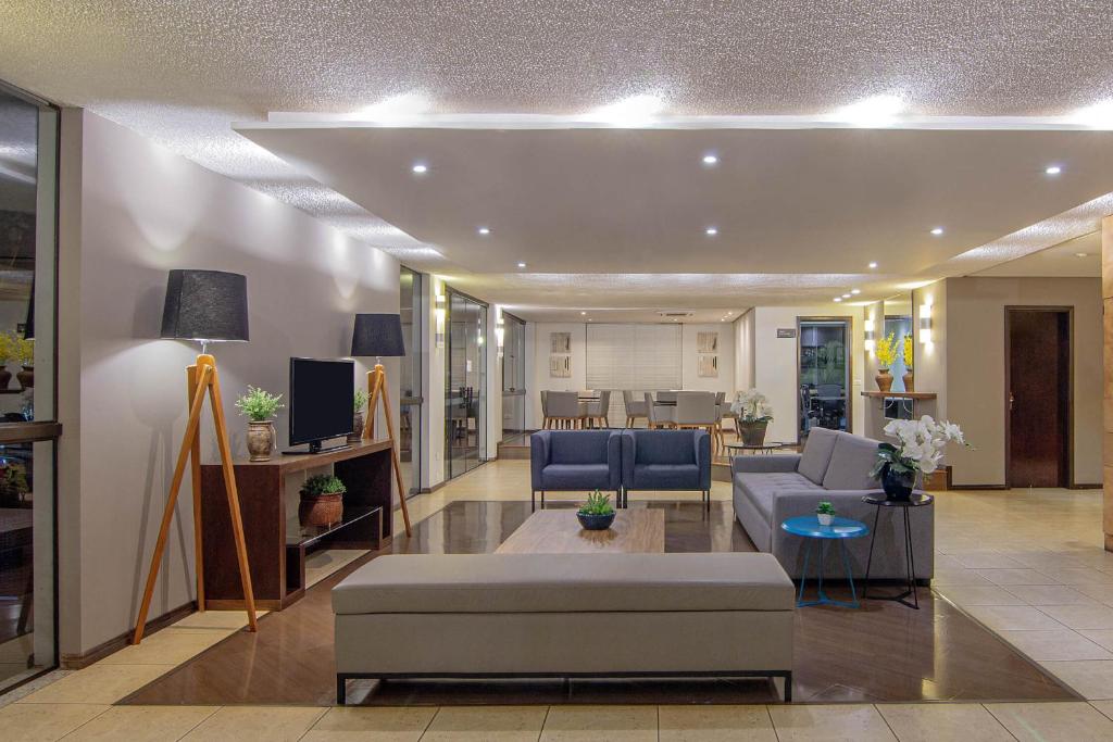 una sala de estar con un sofá y una mesa en Hotel Deville Express Cascavel, en Cascavel