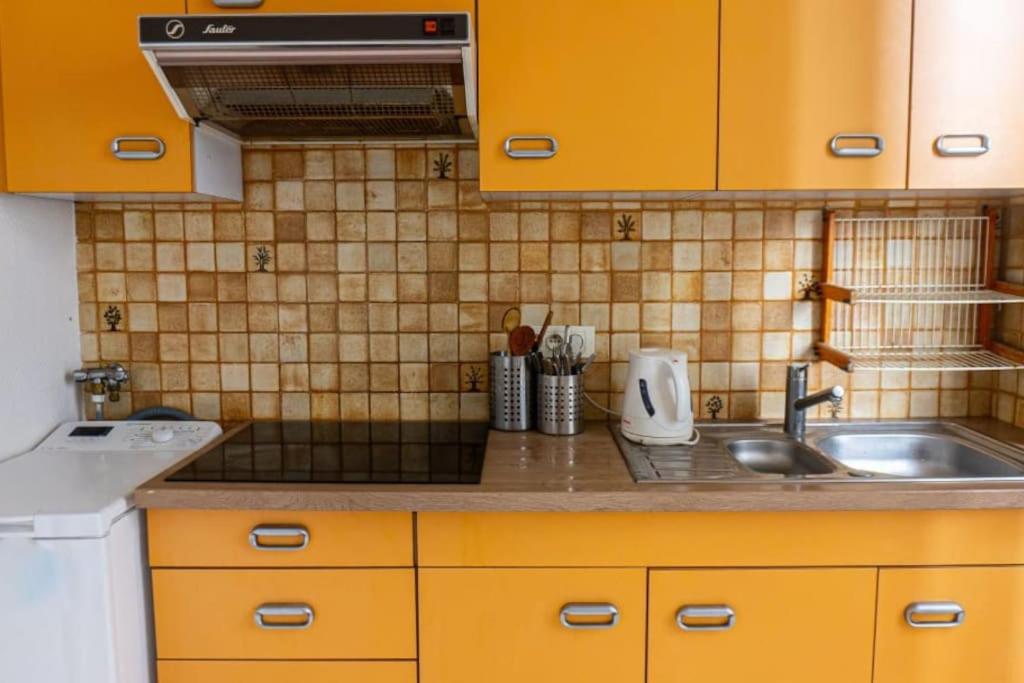 - une cuisine avec des placards jaunes et un évier dans l'établissement calm retreat near Montrouge, à Villejuif