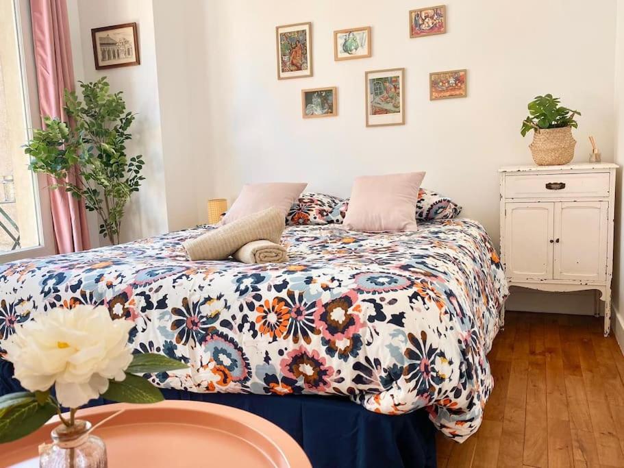 une chambre avec un lit avec une couette fleurie dans l'établissement Superbe studio en hypercentre, à Tours