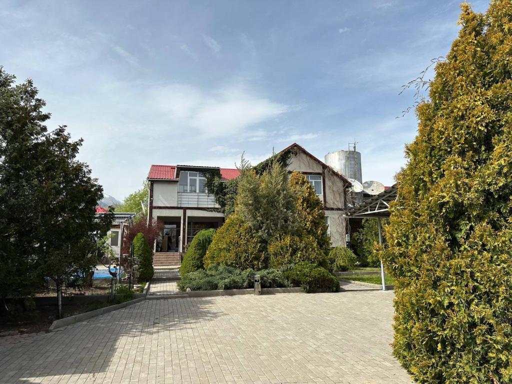 a house with a brick driveway in front of a building at Любимый in Cholpon-Ata