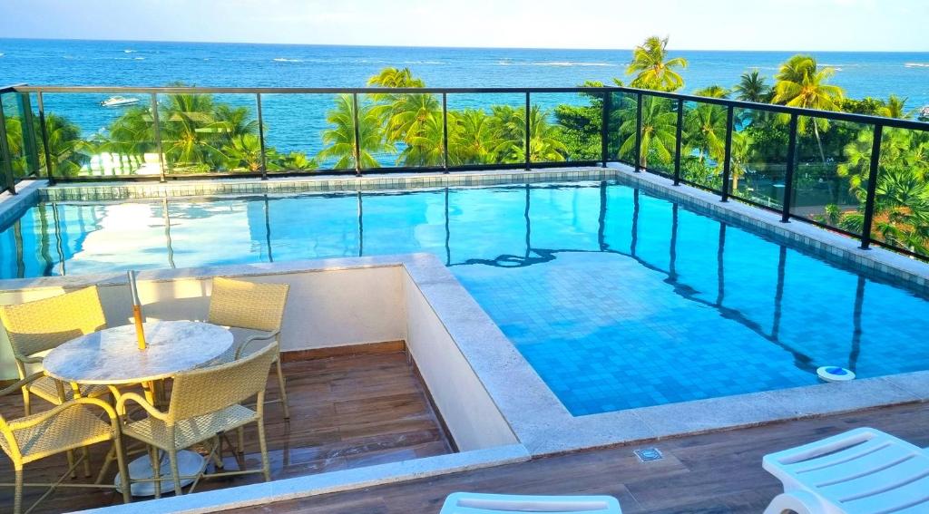 a swimming pool with a view of the ocean at Rooftop103-Tamandaré in Tamandaré