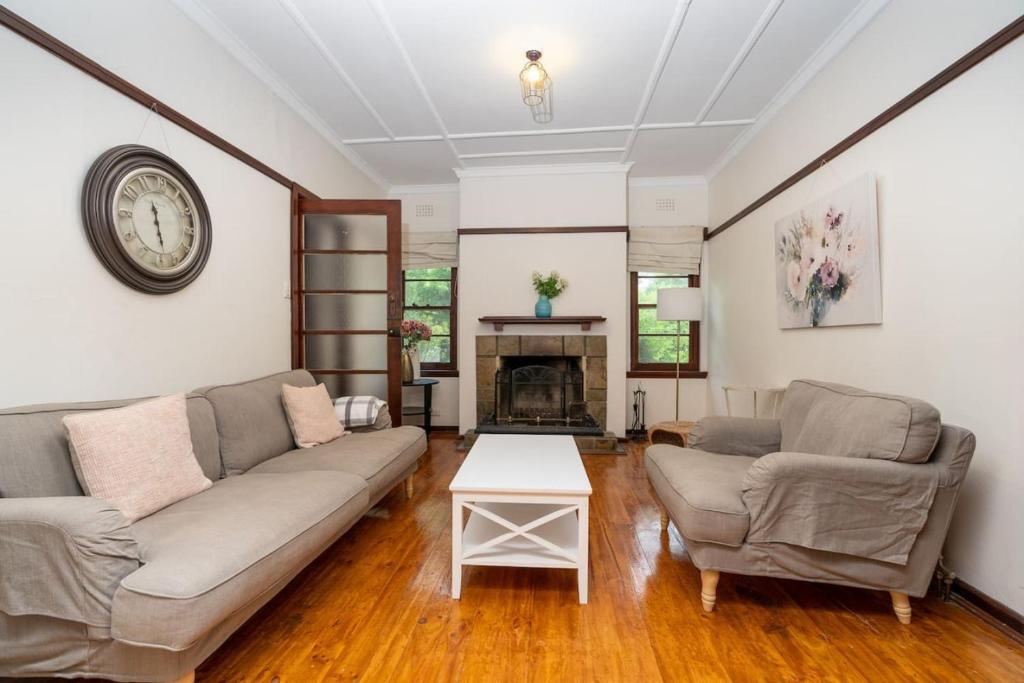 un soggiorno con due divani e un camino di Beautifully Renovated Inner North Residence - Hosted by CanStay a Canberra