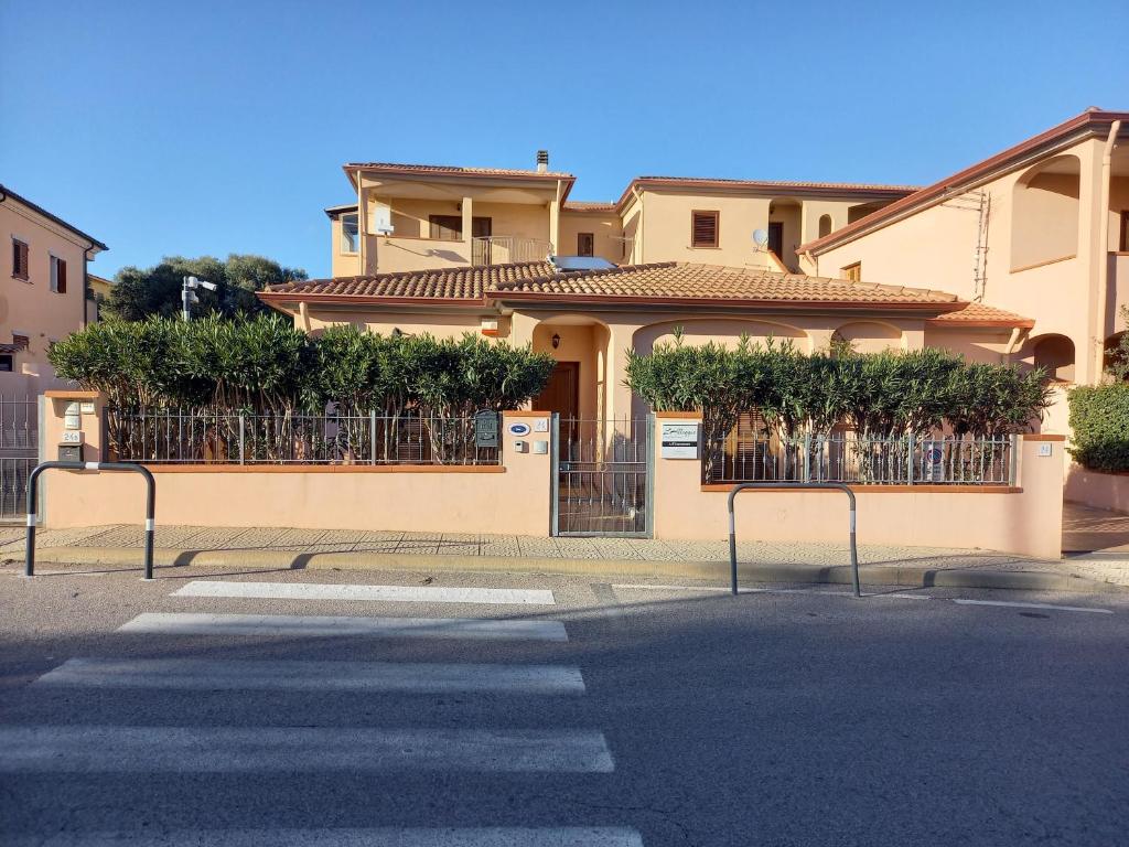 a house with a gate and bushes on it at L'Alloggio-Not just rooms in Olbia