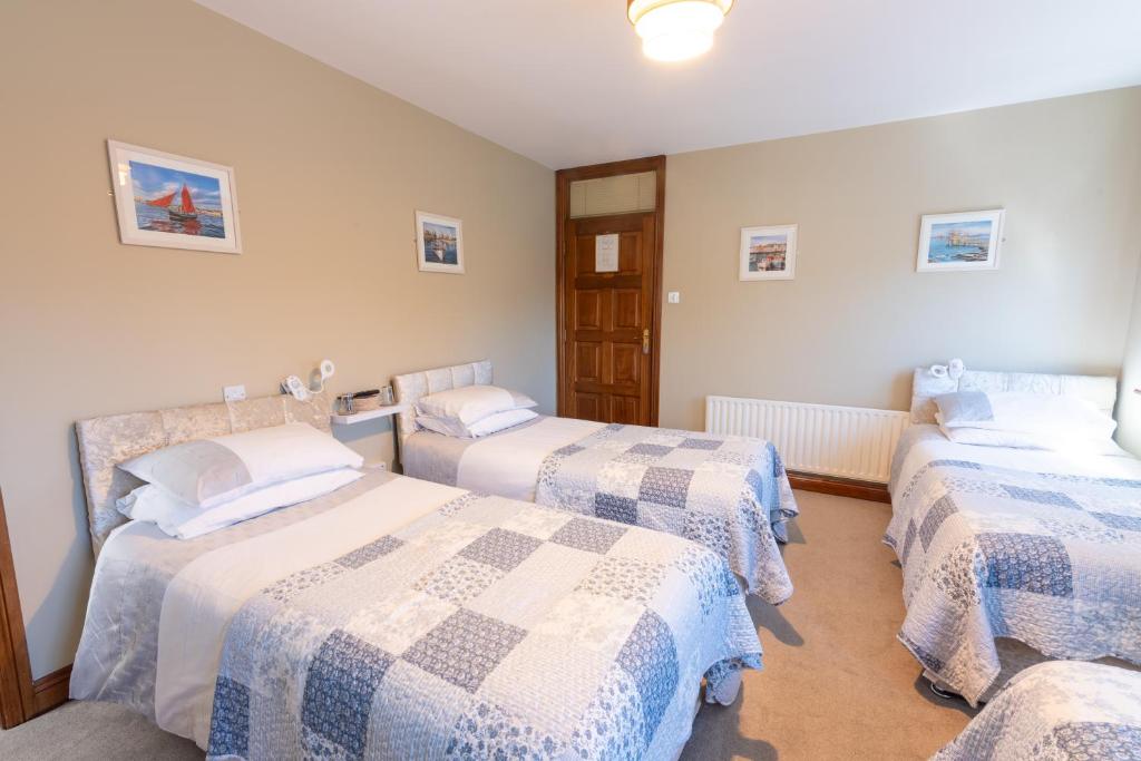 a bedroom with two beds with blue and white sheets at AVALON HOUSE in Galway