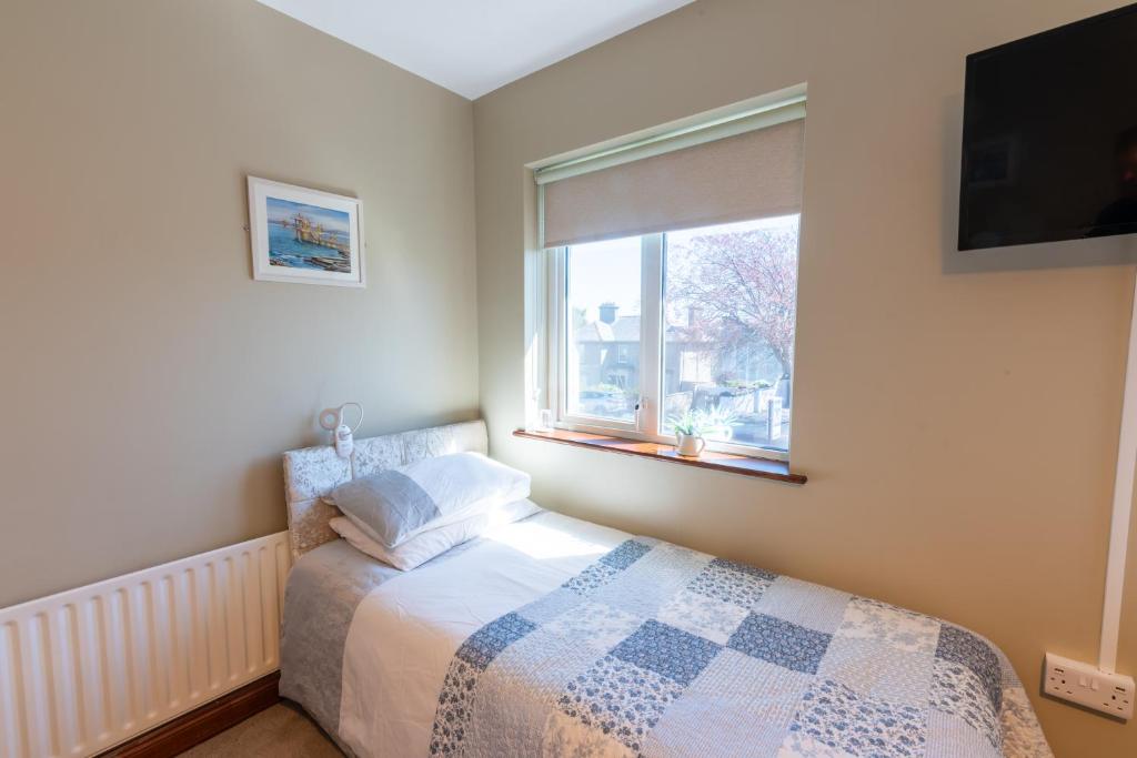a bedroom with a bed and a window at AVALON HOUSE in Galway