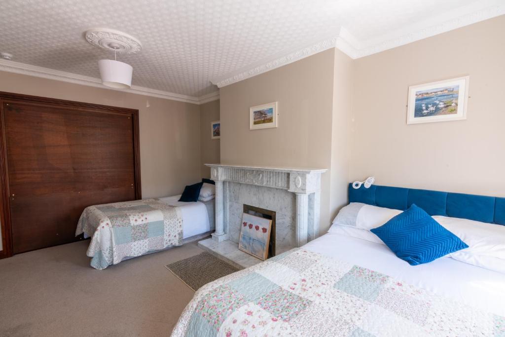 a bedroom with two beds and a fireplace at AVALON HOUSE in Galway
