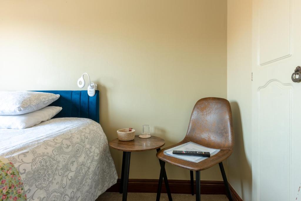 a bedroom with a chair next to a bed at AVALON HOUSE in Galway