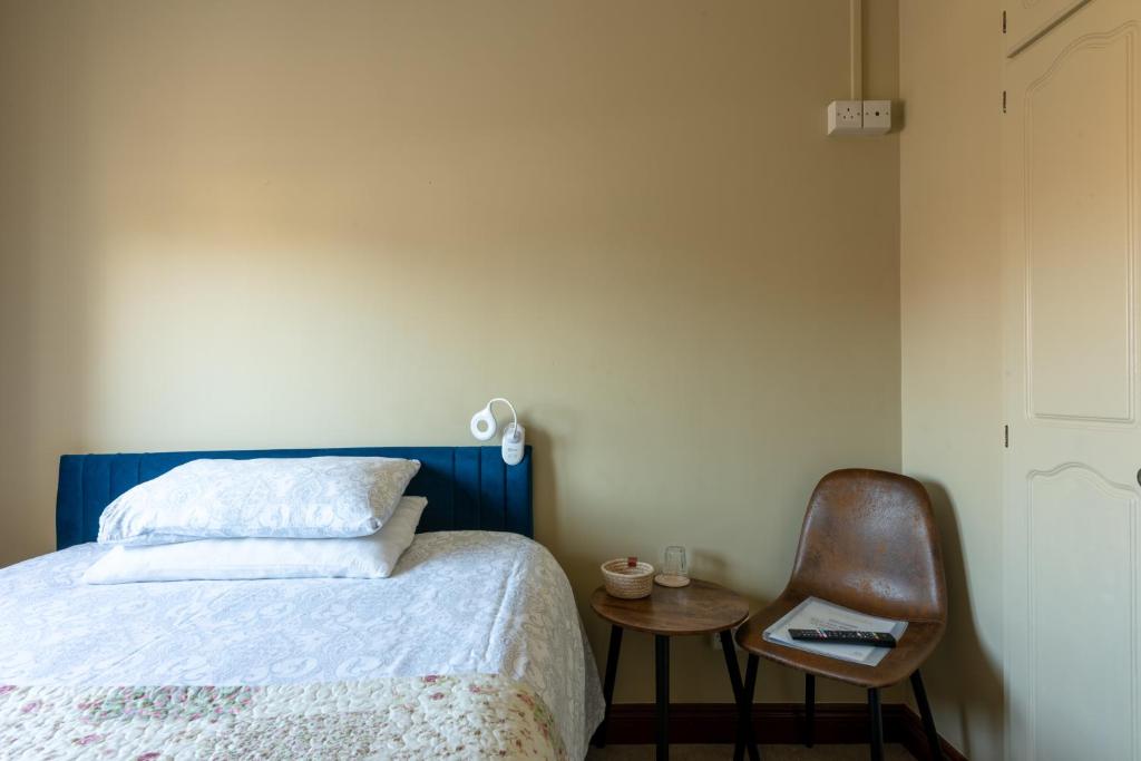 a bedroom with a bed and a chair and a table at AVALON HOUSE in Galway