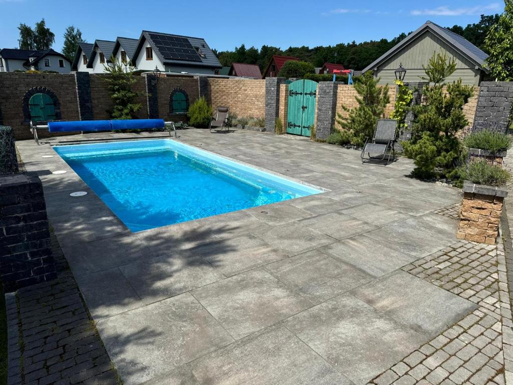 a swimming pool in a yard with a patio at Willa Relaksowa in Karwia