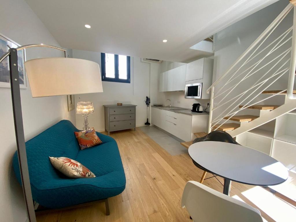 un salon avec un canapé bleu et une table dans l'établissement Studio Beautes FSHH, à Nice