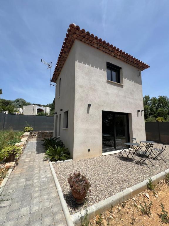 une maison avec deux chaises devant elle dans l'établissement Petite villa paisible, à Hyères