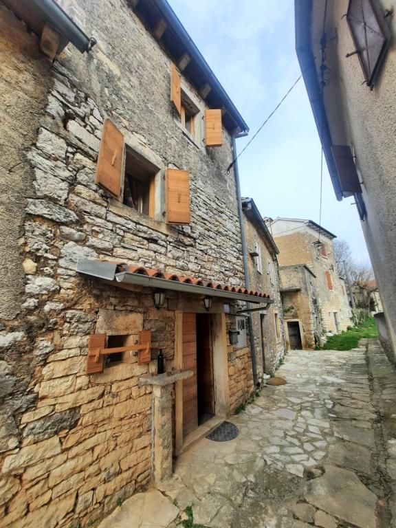 an old stone building with wooden windows on a street at Apartment Bike in Žminj