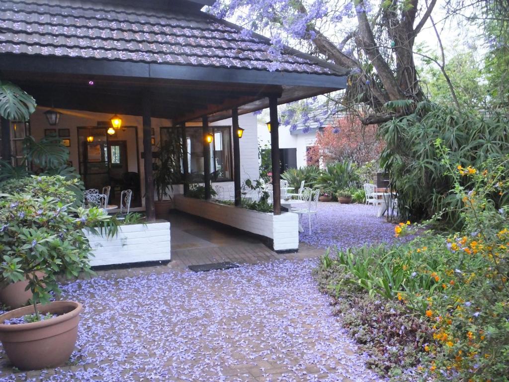 un porche de una casa con un montón de plantas en Karula Hotel en White River