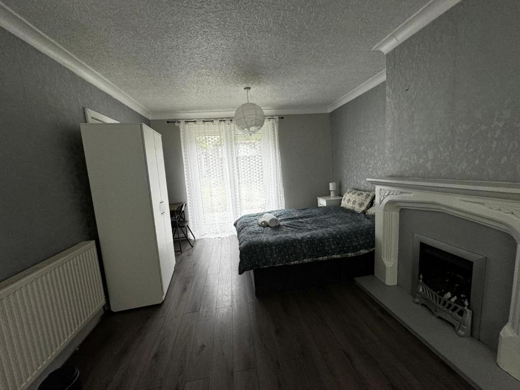 R&S Double Bedroom X في ميدلتون: غرفة معيشة مع سرير ومدفأة