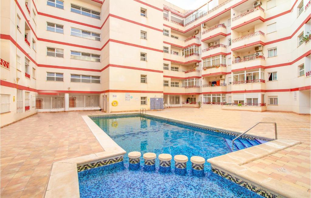 an apartment building with a swimming pool in a courtyard at Amazing Apartment In Torrevieja in Torrevieja