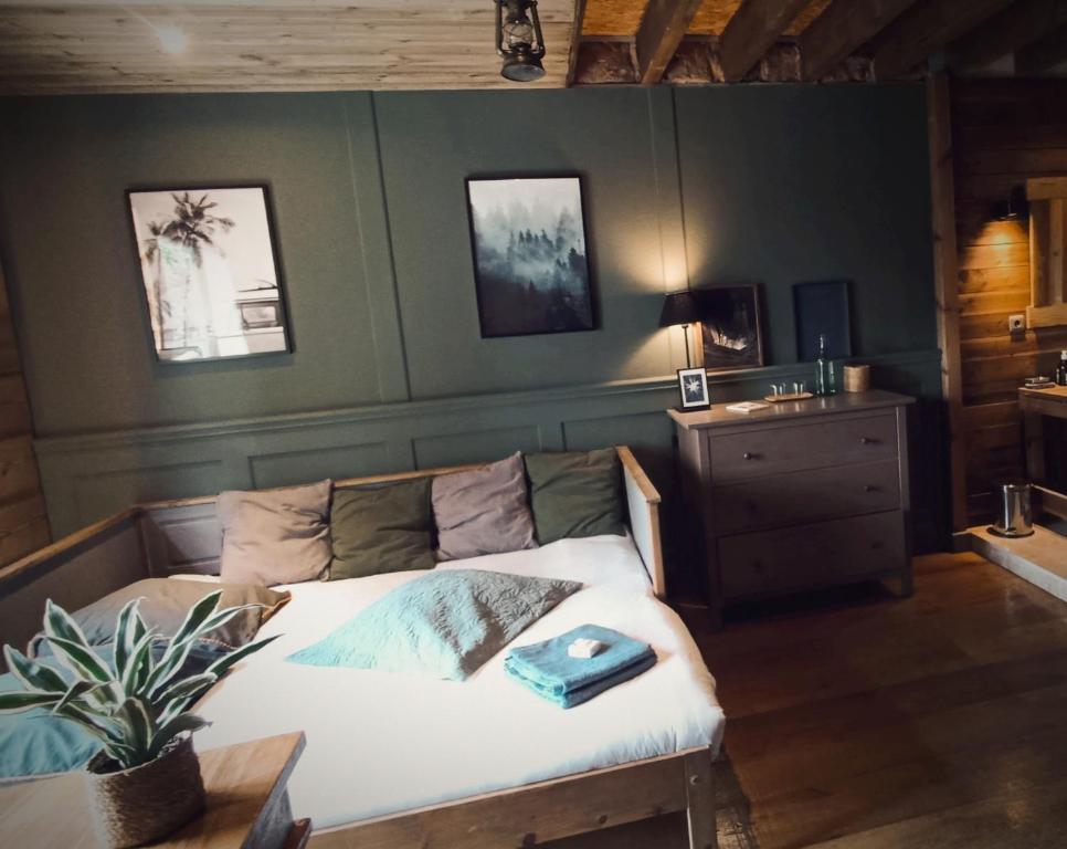 - une chambre avec un lit avec une plante et une table dans l'établissement Studio Nature proche Paris, à Béthemont-la-Forêt