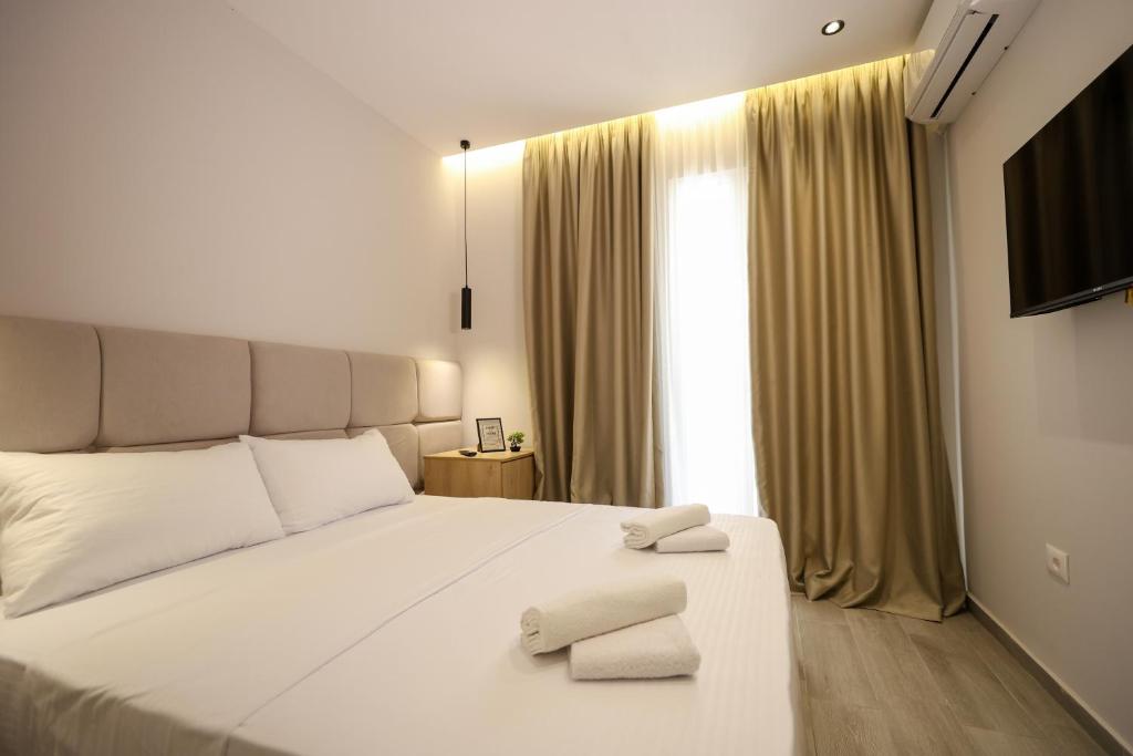 a bedroom with a white bed with two towels on it at Blue Studios by Comfort Suites in Golem