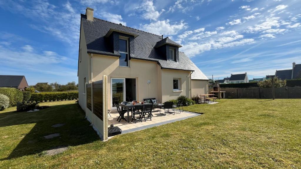 une petite maison avec une table dans une cour dans l'établissement Pen Ar Pont, à Cléder