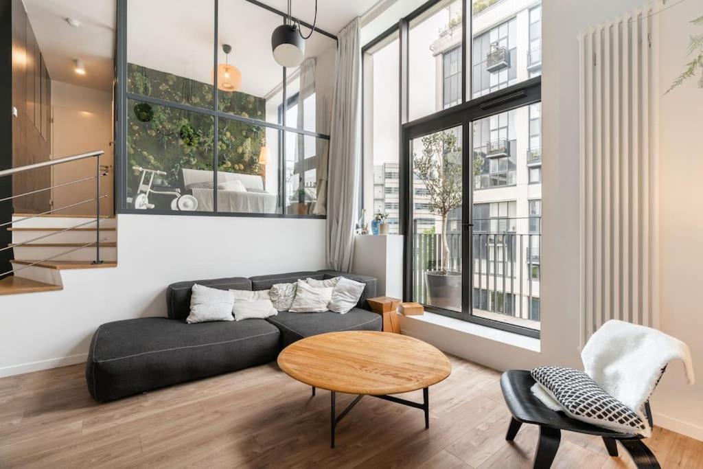 un salon avec un canapé et une table dans l'établissement Appartement moderne Saint-Ouen, à Saint-Ouen